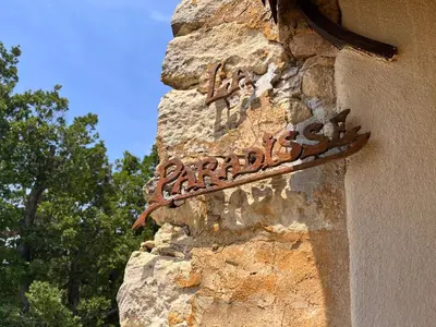 a sign on the side of a stone building at La Paradisse – exceptional Provençal farmhouse (18th century) in Blauvac