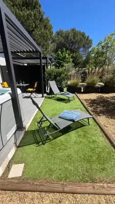 a yard with two lawn chairs and a table at Pause spa sur la route du Ventoux adults only in Carpentras