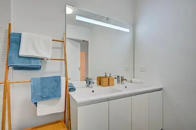a bathroom with a white sink and a mirror at Sublime Appartement 6 couchages avec Parking (Aix-en-Provence) in Aix-en-Provence