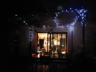 a patio with a table and lights at night at L'ETOURNEAU in Bédoin