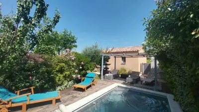 a backyard with a pool and chairs and a house at L'ETOURNEAU in Bédoin