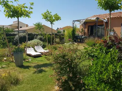 a garden with a couple of benches in the yard at L'ETOURNEAU in Bédoin