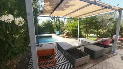 a patio with a swimming pool and a pergola at L'ETOURNEAU in Bédoin