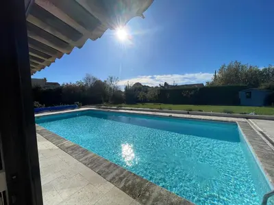 a swimming pool under a pergola at LUBERON SOLEIL ET OLIVIERS in Les Taillades