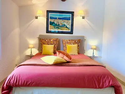 a bedroom with a large red bed with two lamps at LUBERON SOLEIL ET OLIVIERS in Les Taillades