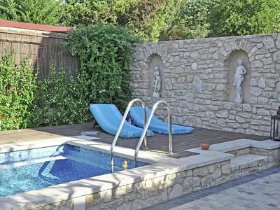 a swimming pool with a blue slide next to a stone wall at Bliss Near Aix-en-Provence in Venelles