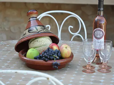 a bowl of fruit on a table with a bottle of wine at Bliss Near Aix-en-Provence in Venelles