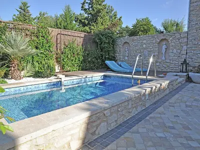 a swimming pool in a backyard with two blue lounge chairs at Bliss Near Aix-en-Provence in Venelles
