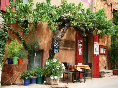 a table and chairs in front of a building with a tree at Bliss Near Aix-en-Provence in Venelles