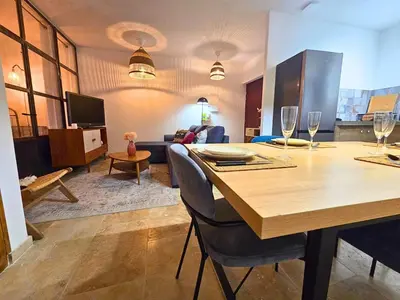 a living room with a table and a couch at Jacuzzi & Terrasse en bord de rivière in Fontaine-de-Vaucluse