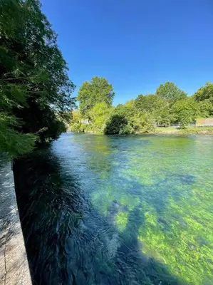 a river with green water and trees on the side at Jacuzzi & Terrasse en bord de rivière in Fontaine-de-Vaucluse