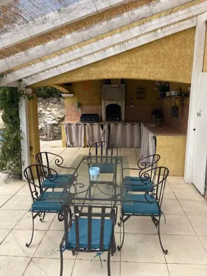 a glass table and chairs on a patio at Villa provençale 8 personnes in Ventabren