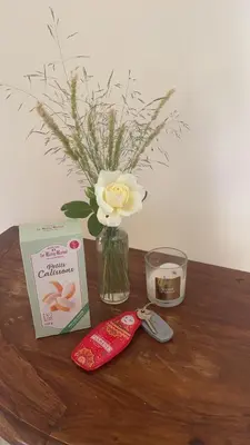a table with a vase with a flower and a candle at Villa provençale 8 personnes in Ventabren