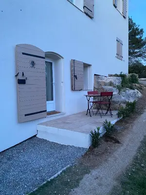 a red bench sitting on a patio outside of a building at La studette provençale in Jouques