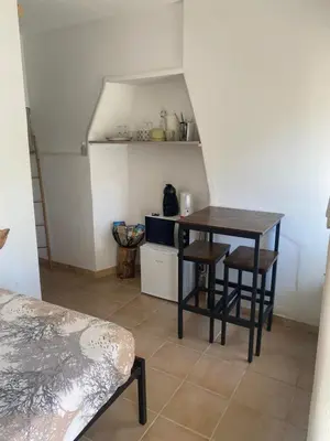 a small kitchen with a table and chairs in a room at La studette provençale in Jouques