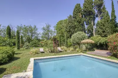 a swimming pool in a yard with trees at Le Mas des Anges in Cabannes