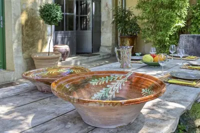 a table with two large pots on top of a table at Le Mas des Anges in Cabannes