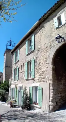 an old brick building with an archway and a building at L'appartement de l'Arche in Châteauneuf-de-Gadagne