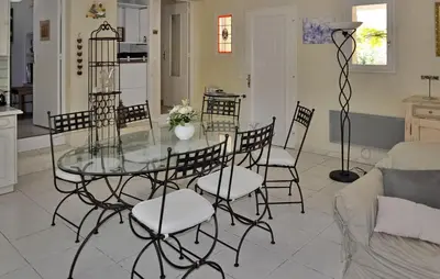 a dining room with a glass table and chairs at La Villa Du Soleil in Lacoste
