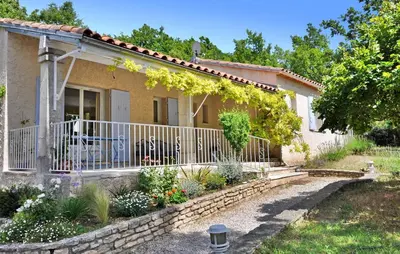 a house with a fence and flowers in front of it at La Villa Du Soleil in Lacoste