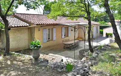 a small house with a patio and a table at La Villa Du Soleil in Lacoste