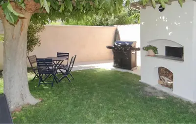 a patio with a table and chairs under a tree at La Villa De Sacha in Vedène