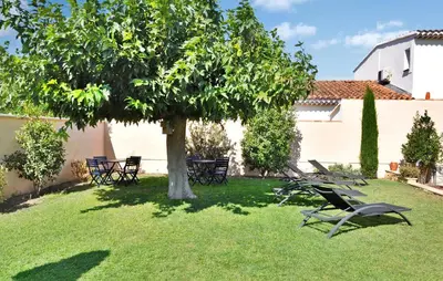 a group of chairs under a tree in a yard at La Villa De Sacha in Vedène