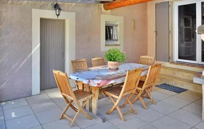 a table with chairs and a potted plant on a patio at La Villa De Sacha in Vedène