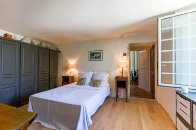 a bedroom with a bed and two tables and a window at le mas du lavoir in Gordes