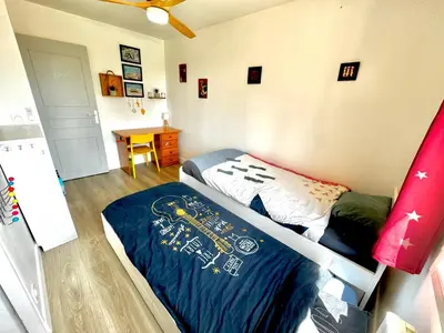 a bedroom with a bed and a desk in it at Villa entière au calme avec piscine partagée et jardin in Pertuis