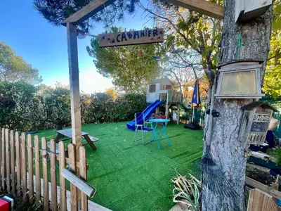 a yard with a playground and a sign on a tree at Villa entière au calme avec piscine partagée et jardin in Pertuis