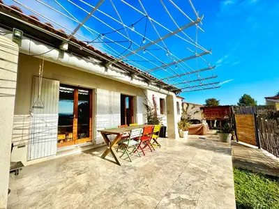 a patio with a wooden table and chairs on it at Villa entière au calme avec piscine partagée et jardin in Pertuis