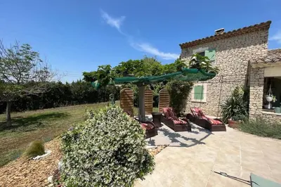 a patio with chairs and an umbrella in front of a house at 84A - 