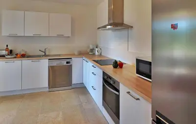 a kitchen with white cabinets and a stainless steel refrigerator at Li Vue Vent in Saint-Rémy-de-Provence