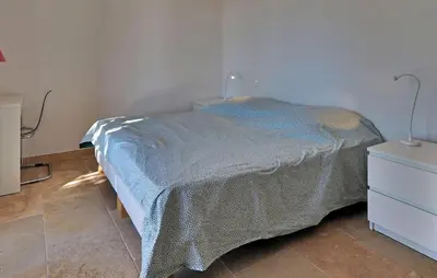 a bedroom with a bed with a blue blanket on it at Li Vue Vent in Saint-Rémy-de-Provence