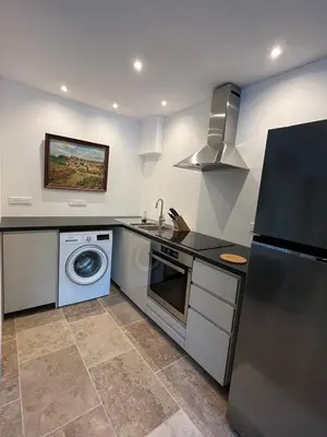 a kitchen with a washer and a sink and a dishwasher at The Garden View in Le Thor