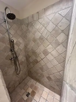 a bathroom with a shower with a tiled floor at The Garden View in Le Thor
