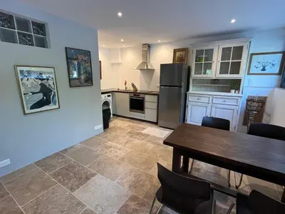 a kitchen with a table and a refrigerator at The Garden View in Le Thor