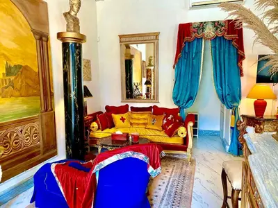a living room with a yellow couch and blue curtains at Appartement de luxe : Le Petit Trianon au coeur d'Aix-en-Provence in Aix-en-Provence