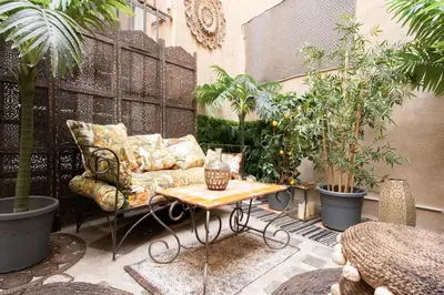 a patio with a couch and a table and plants at Appartement de luxe : Le Petit Trianon au coeur d'Aix-en-Provence in Aix-en-Provence
