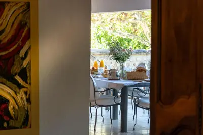 a dining room table with chairs and a table with food on it at Domaine de Valloncourt in Cheval-Blanc