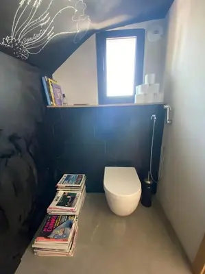 a bathroom with a toilet and a window and books at L'Artiste - Villa 5 min du centre historique d'Aix in Aix-en-Provence