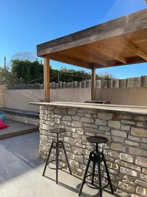 two bar stools in front of a stone wall at L'Artiste - Villa 5 min du centre historique d'Aix in Aix-en-Provence