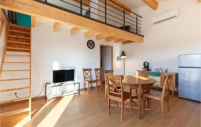 a kitchen and dining room with a table and a refrigerator at Beautiful Apartment In Eyragues in Eyragues