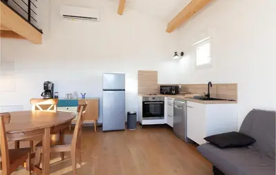 a kitchen with a table and a kitchen with a refrigerator at Beautiful Apartment In Eyragues in Eyragues