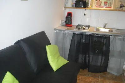 a black couch in a kitchen with a sink at Lou mas li Pitchoun 