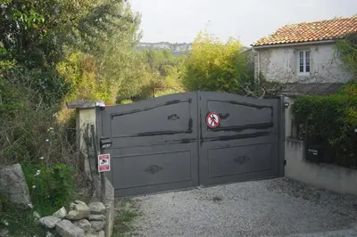 a black gate with a red cross on it at Lou mas li Pitchoun 