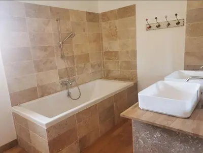 a bathroom with a bath tub and a sink at Maison de la bonne fontaine. in Lauris