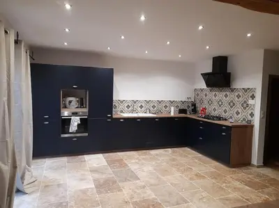 a kitchen with a counter and a stove top oven at Maison de la bonne fontaine. in Lauris