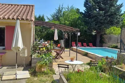 a backyard with a swimming pool and an umbrella at Au goût du miel. Luberon-Provence. in Maubec